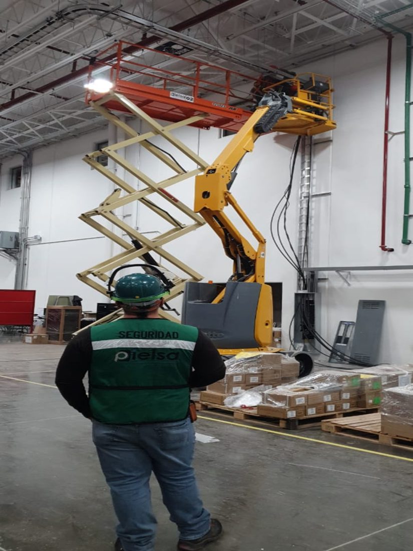 Plataforma de tijera el&eacute;ctrica en trabajos de altura dentro de planta