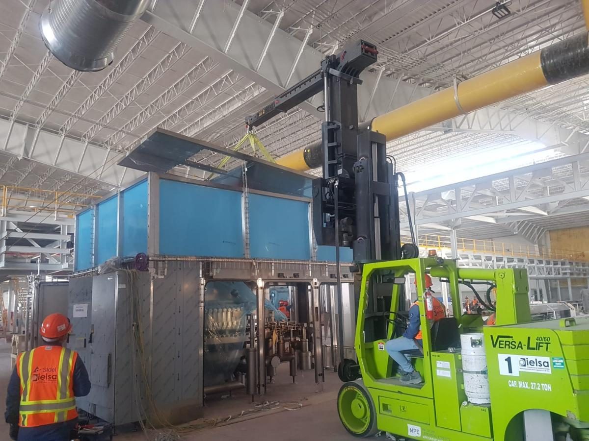 Montacargas de alto tonelaje de PIELSA moviendo maquinaria dentro de una planta industrial
